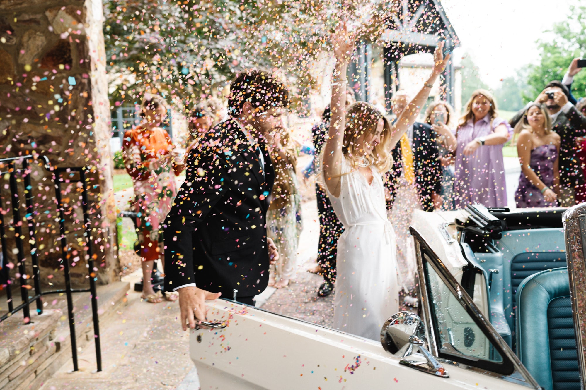 Bride and groom making a grand exit through a cloud of colorful confetti