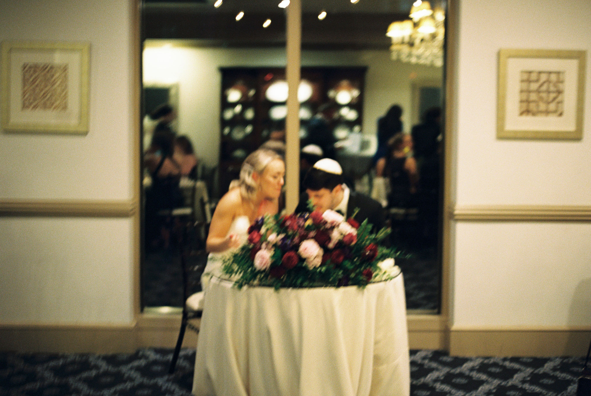 Bride and groom sharing a quiet moment at their sweetheart table, film photography