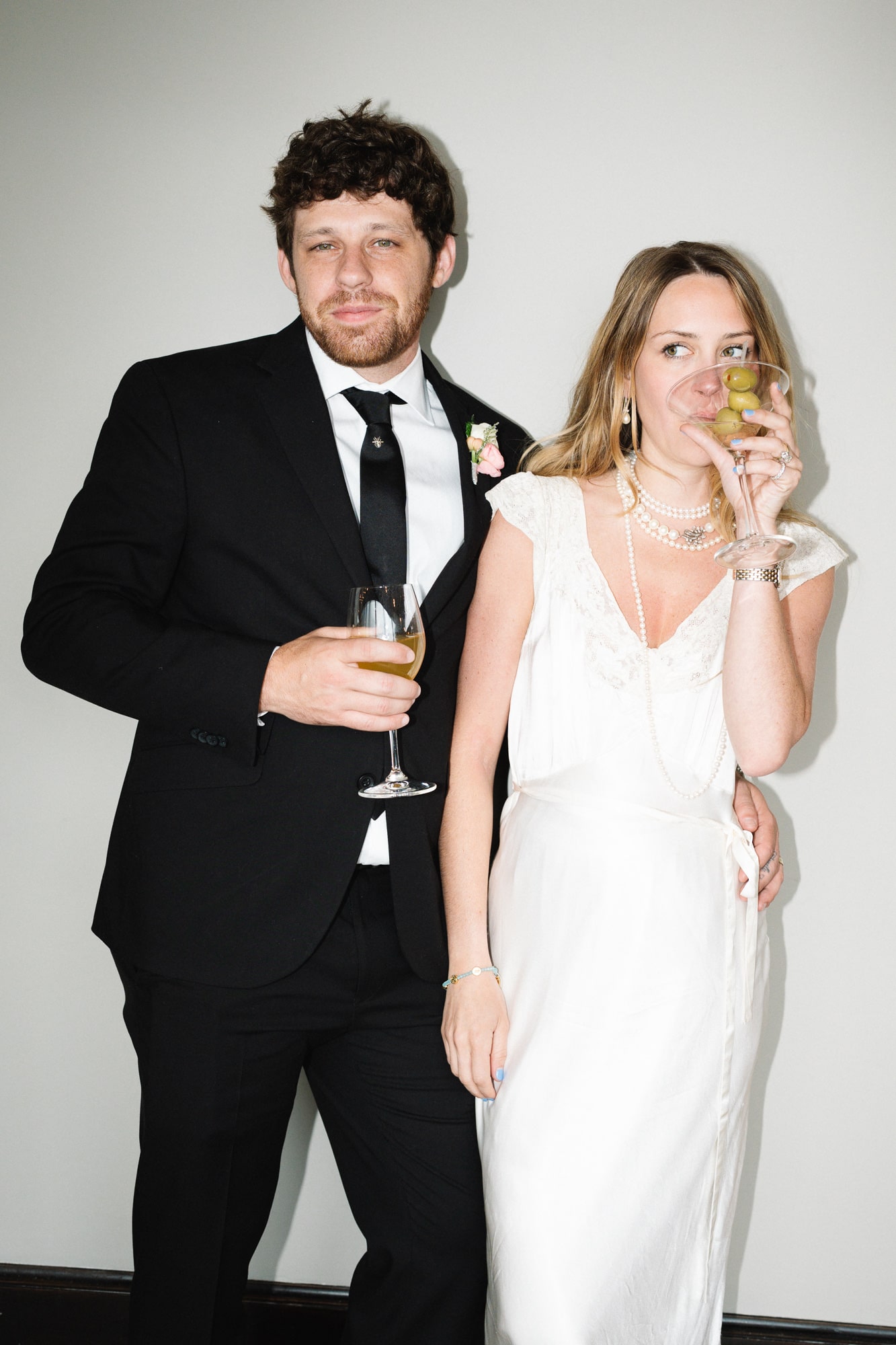Bride and groom posing with champagne glasses at their wedding reception